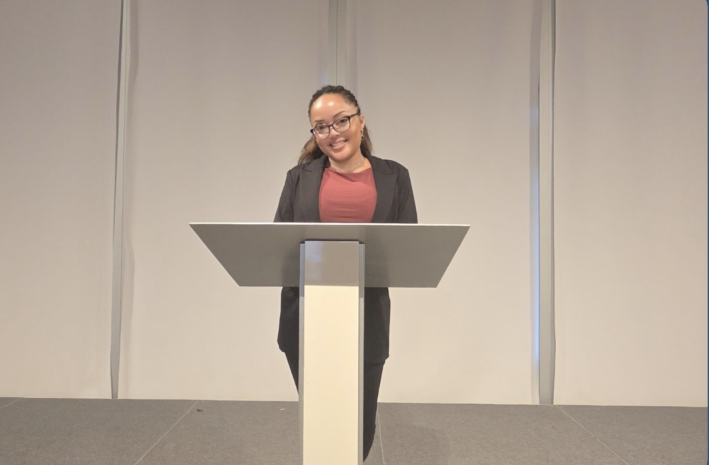Dr. Celeste Chamberlain delivering a quantum sensing briefing from a lectern